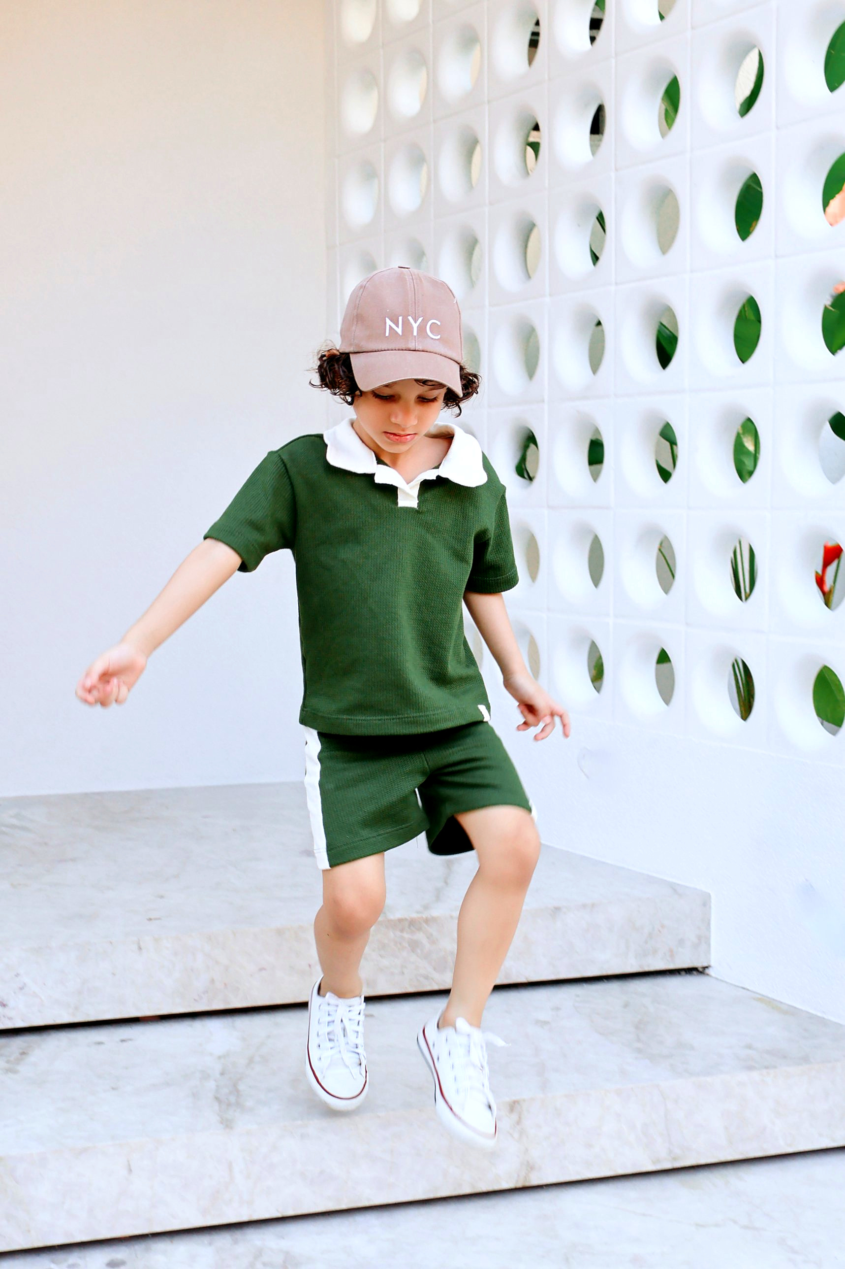 Menino vestindo camisa polo verde da Miki